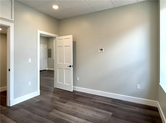 an empty room with wooden floor and entrance