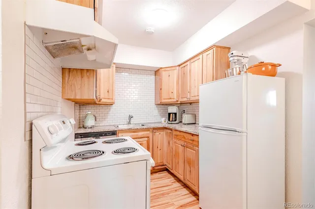 a kitchen with a refrigerator sink stove and cabinets