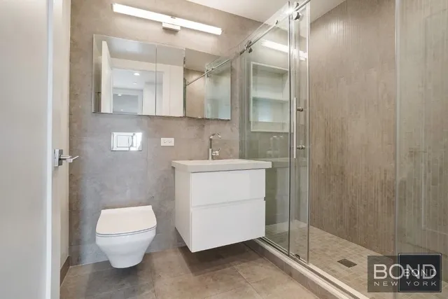 a bathroom with a sink a toilet and shower