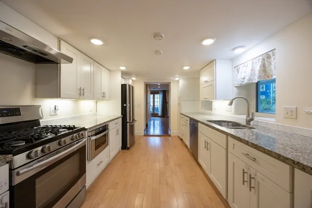 a large kitchen with stainless steel appliances granite countertop a stove and a sink
