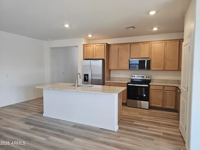 a kitchen with stainless steel appliances a sink stove and refrigerator