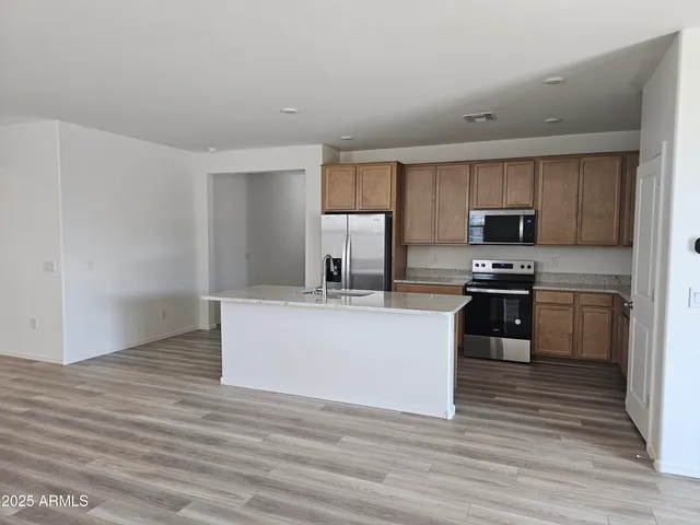a kitchen with stainless steel appliances granite countertop a stove a sink and a refrigerator