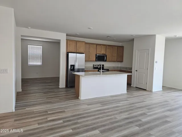 a view of kitchen with stainless steel appliances granite countertop a stove a sink and a refrigerator