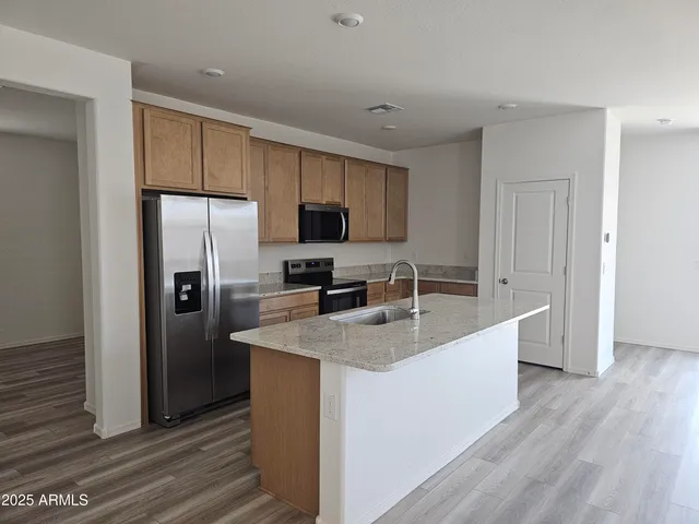 a kitchen with stainless steel appliances granite countertop a sink a refrigerator and a stove