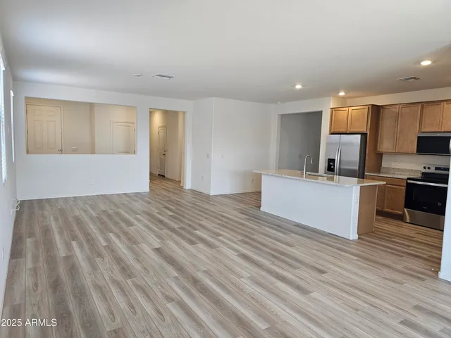 a view of kitchen with wooden floor and electronic appliances