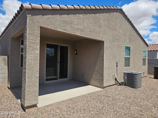 a backyard of a house with barbeque oven and glass door