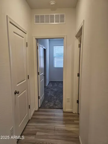 a view of a hallway with wooden floor and staircase