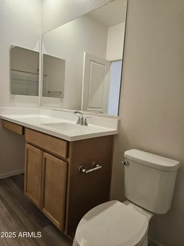 a bathroom with a granite countertop toilet sink and mirror
