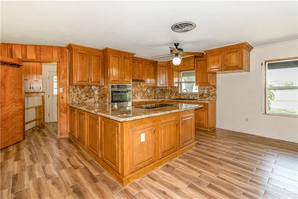 a kitchen with stainless steel appliances granite countertop a stove and a wooden cabinets