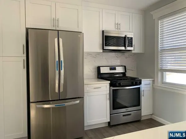 a metallic refrigerator freezer sitting in a kitchen