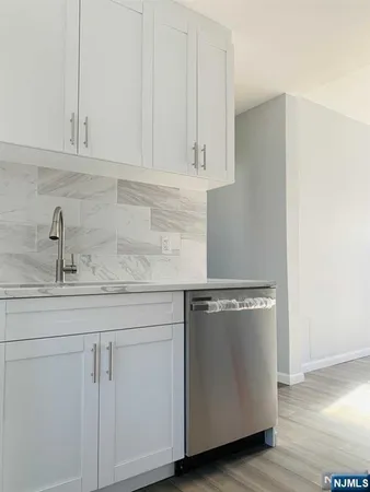 a kitchen with granite countertop white cabinets and white appliances