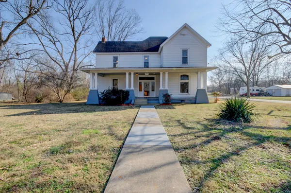 a front view of house with yard and trees around