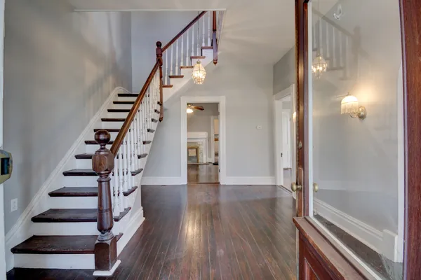 an empty room with wooden floor a ceiling fan and fireplace
