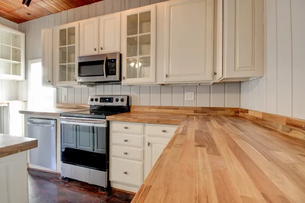 a view of empty room with wooden floor fireplace and window