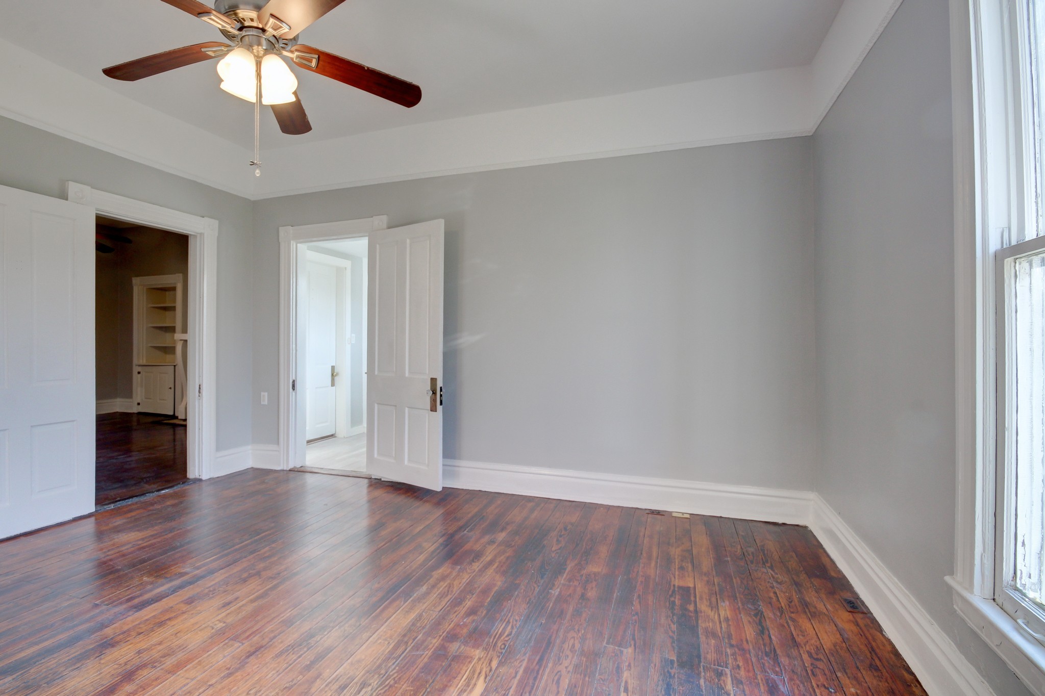 389 3rd Street Guthrie, KY 42234 - Photo 28 of 69 an empty room with wooden floor chandelier fan and windows