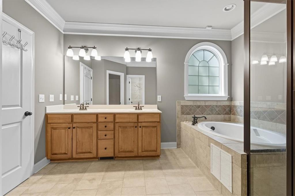 16 Nelson Boulevard Northwest Rome, GA 30165 - Photo 15 of 43 a spacious en suite bathroom with a double vanity sink a mirror a bathtub and window