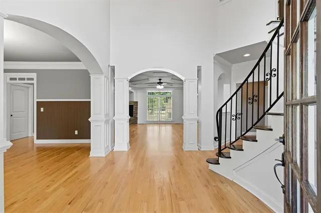 a view of a hallway with wooden floor and staircase