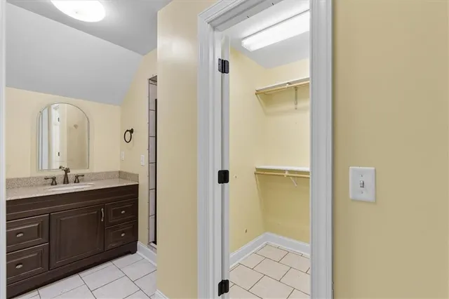 a bathroom with a granite countertop sink mirror and a toilet