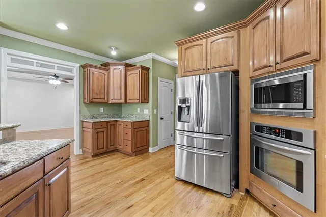 a kitchen with granite countertop stainless steel appliances and wooden cabinets