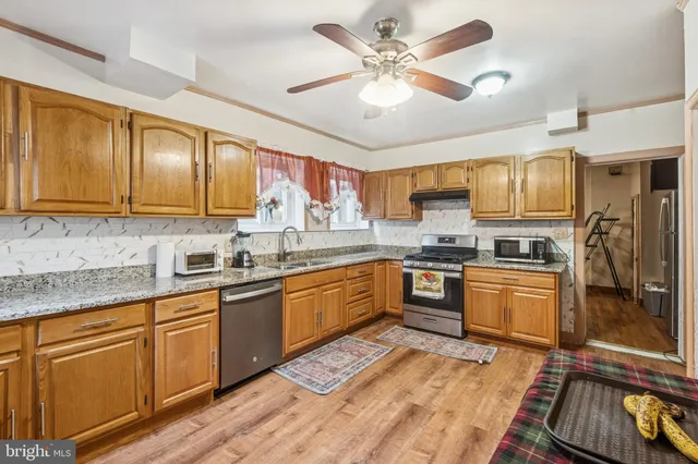 a kitchen with granite countertop appliances cabinets and a sink