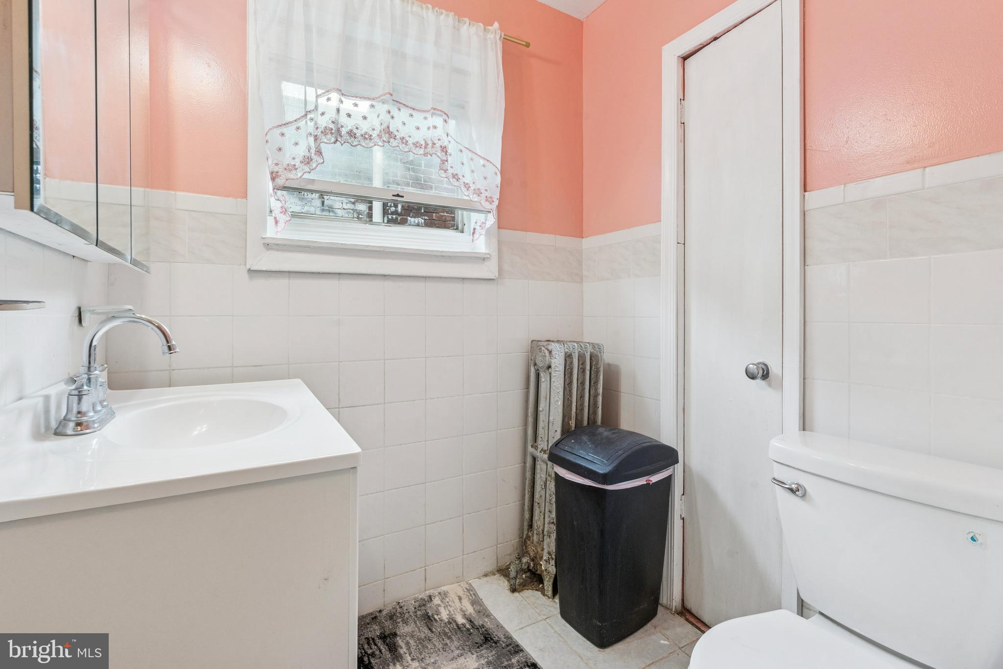 4725 Rosehill Street Philadelphia, PA 19120 - Photo 8 of 26 a bathroom with a toilet sink and mirror