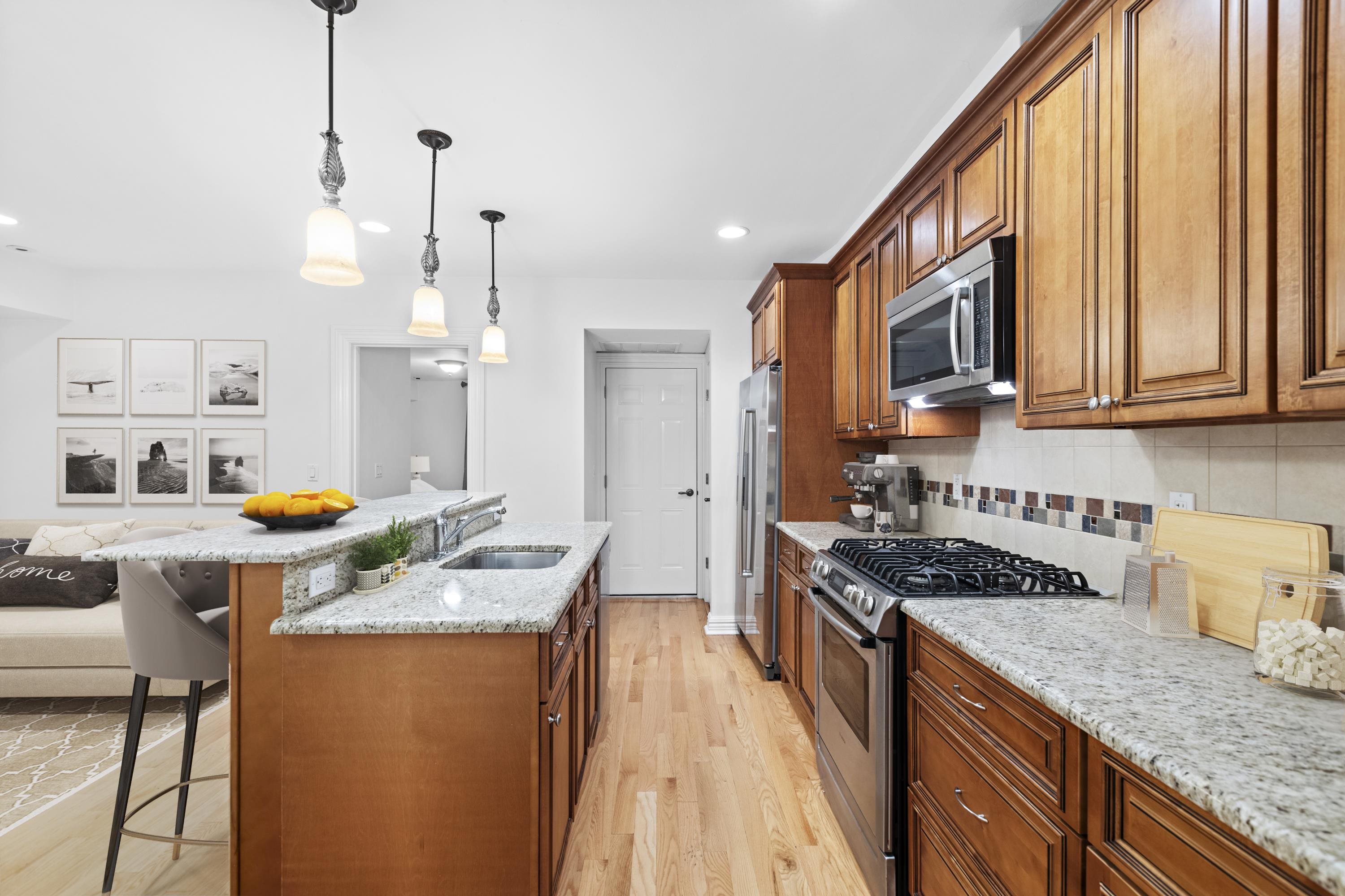 720 Bloomfield Street, Unit 1 Hoboken, NJ 07030 - Photo 3 of 13 a kitchen with stainless steel appliances granite countertop a stove a sink dishwasher and a refrigerator with wooden floor