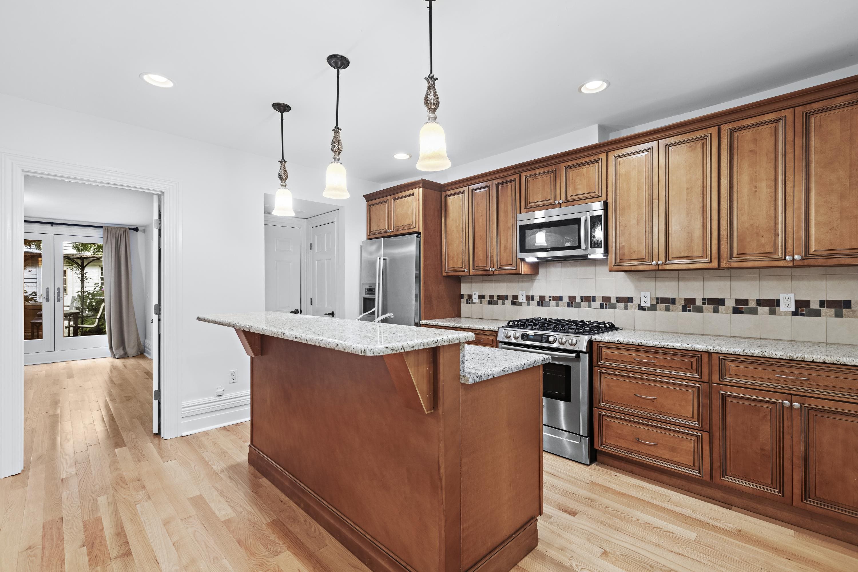 720 Bloomfield Street, Unit 1 Hoboken, NJ 07030 - Photo 4 of 13 a kitchen with stainless steel appliances granite countertop a stove a sink dishwasher a refrigerator and a oven with wooden floor