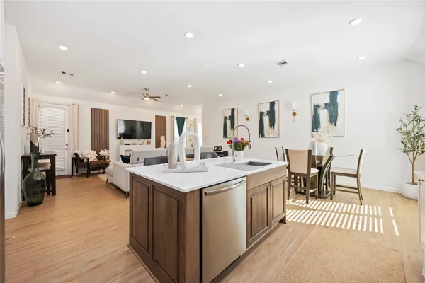 a large kitchen with a large counter top furniture a sink and stainless steel appliances