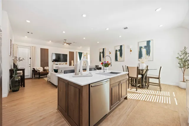 a large kitchen with a large counter top furniture a sink and stainless steel appliances