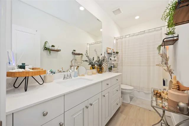 a bathroom with a double vanity sink toilet and shower