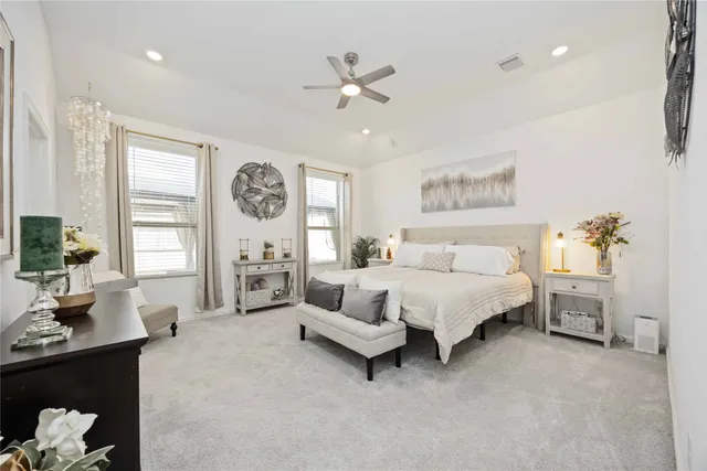 a spacious bedroom with a large bed and a chandelier