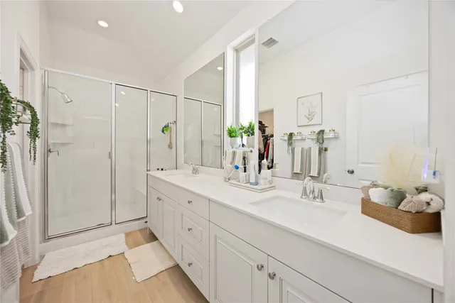 a bathroom with a double vanity sink mirror and shower