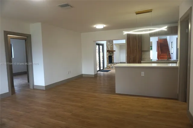 a view of a kitchen with refrigerator and wooden floor