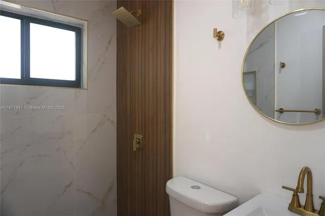 a bathroom with a toilet and a mirror