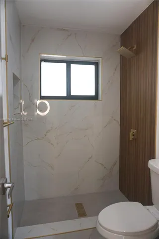 a bathroom with a toilet and a shower