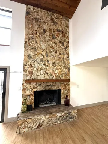 a view of empty room with fireplace and wooden floor