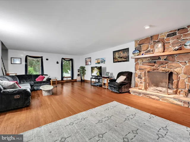 a living room with furniture a fireplace and gym equipment