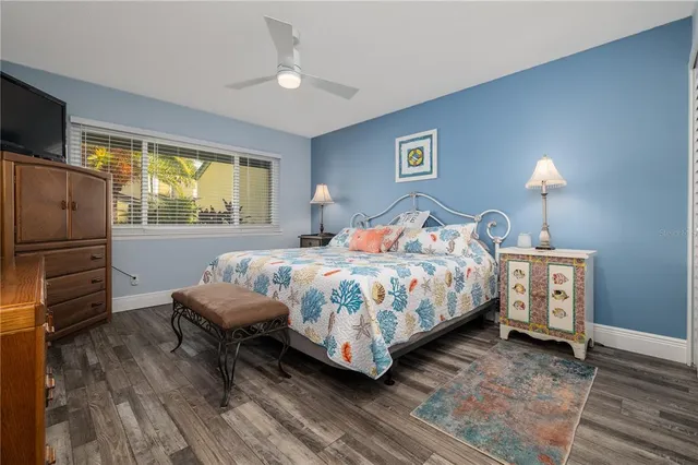 a bedroom with a bed next to a window with a flat screen tv