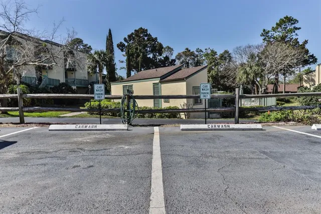a view of a street with a small yard and large trees