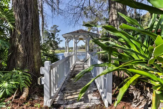 a view of a house with a tree and wooden fence