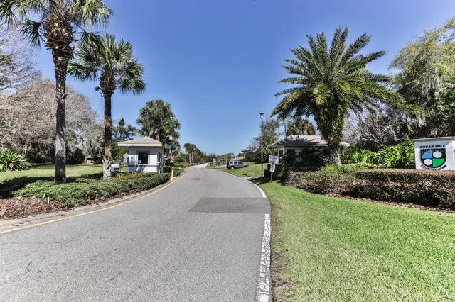 a view of a house with a yard and palm trees