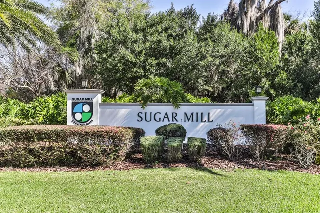 a view of a street sign under a large tree