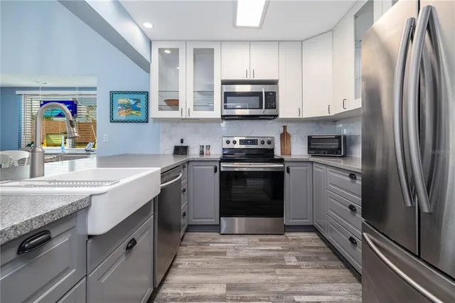 a kitchen with stainless steel appliances granite countertop a refrigerator sink and stove