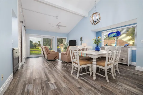 a view of a dining room with furniture a chandelier and wooden floor