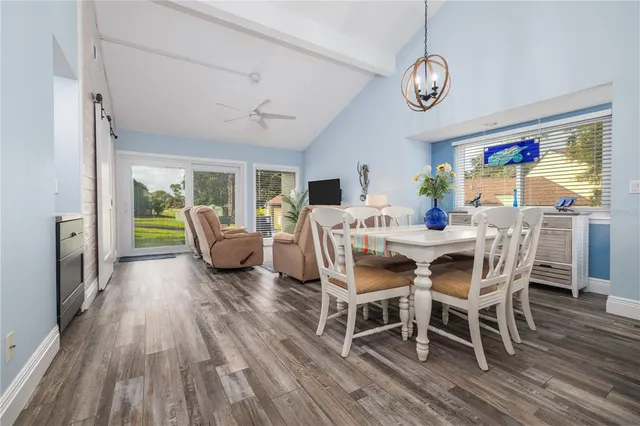a view of a dining room with furniture a chandelier and wooden floor