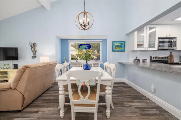 a view of a dining room with furniture a chandelier and wooden floor