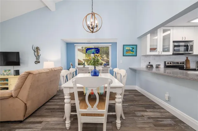 a view of a dining room with furniture a chandelier and wooden floor