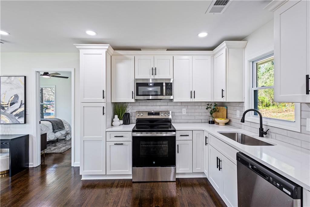 3252 Pinehill Drive Decatur, GA 30032 - Photo 9 of 26 a kitchen with cabinets stainless steel appliances a sink and wooden floor
