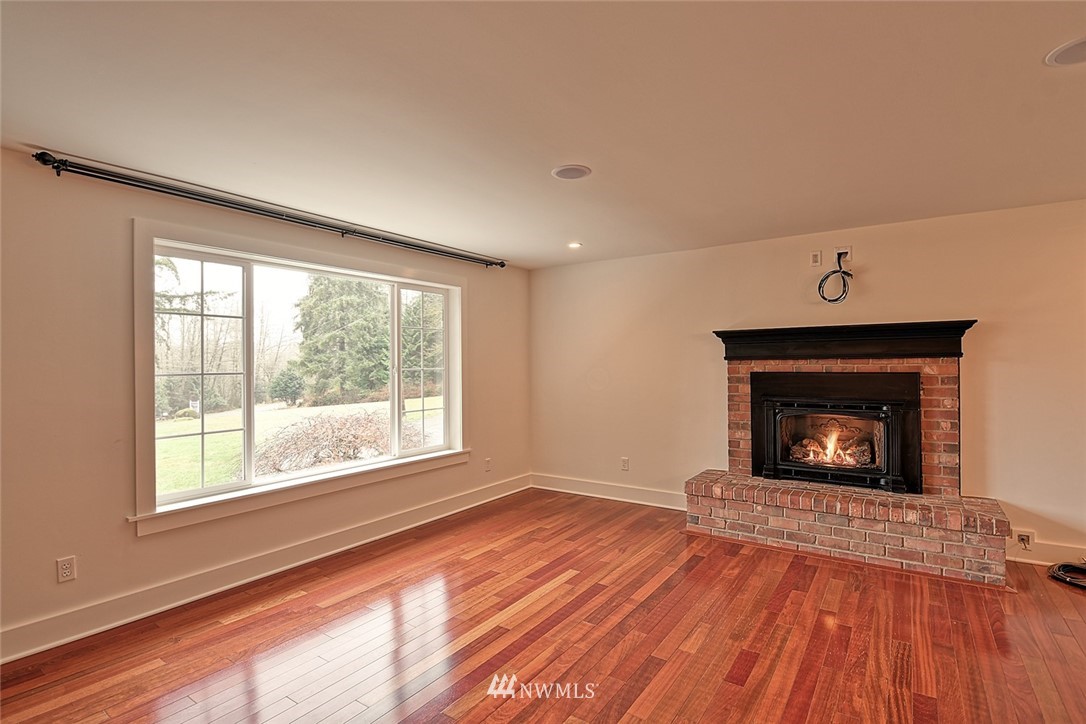 5918 Robe Menzel Road Snohomish, WA 98290 - Photo 20 of 40 a view of an empty room with wooden floor fireplace and a window