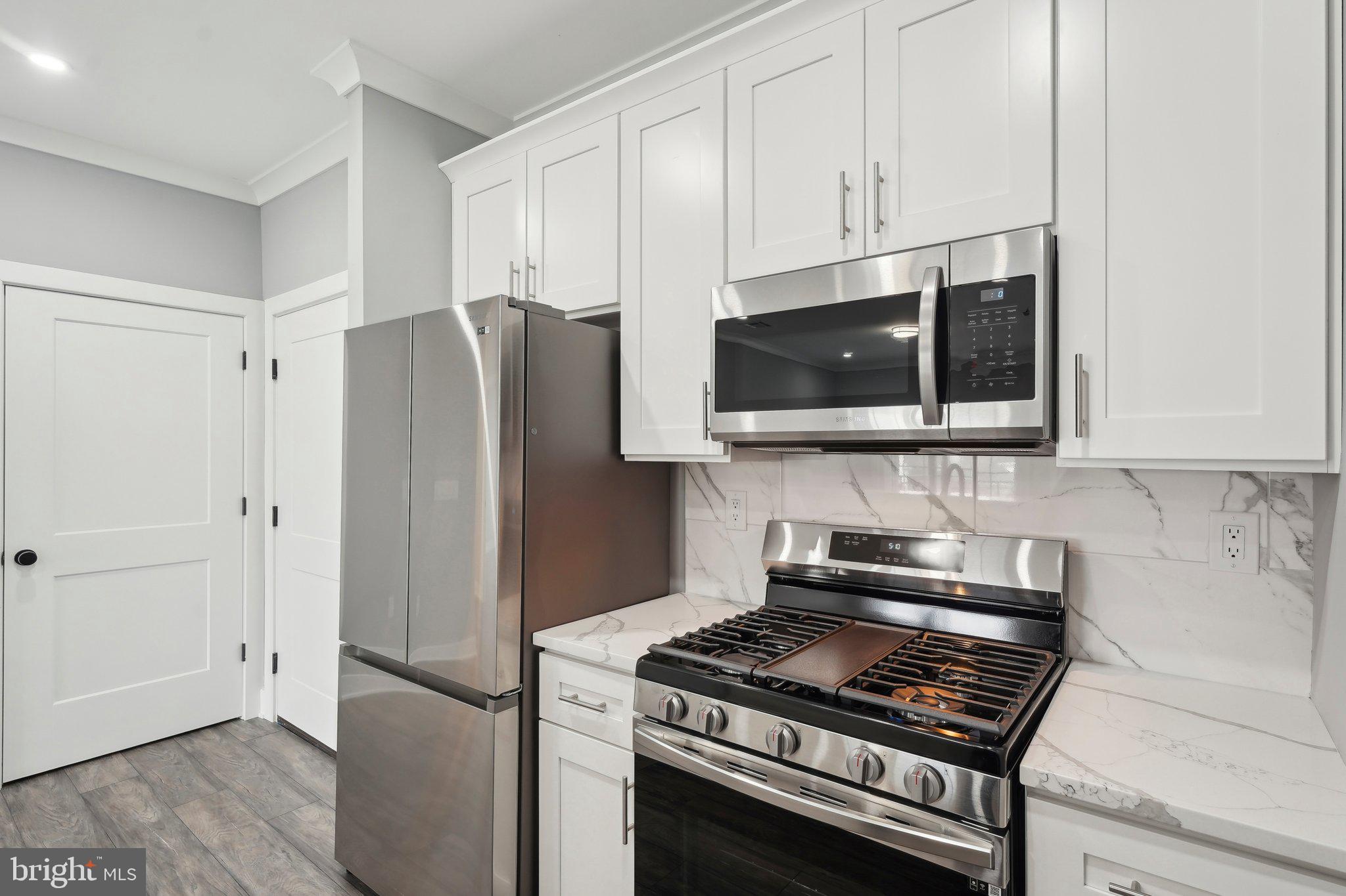 2421 Bristol Road, Unit 310 Warrington, PA 18976 - Photo 6 of 19 a kitchen with stainless steel appliances granite countertop a stove a refrigerator and a microwave